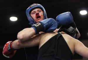 a man wearing boxing gloves and a helmet with blood on his face