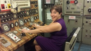 a woman sitting in a chair in front of a control panel