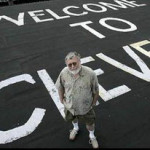 a man standing in front of a welcome sign