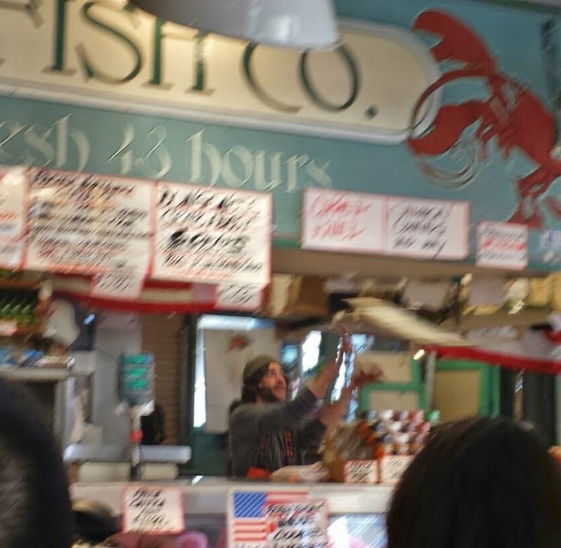 a man standing at a counter in a fish shop