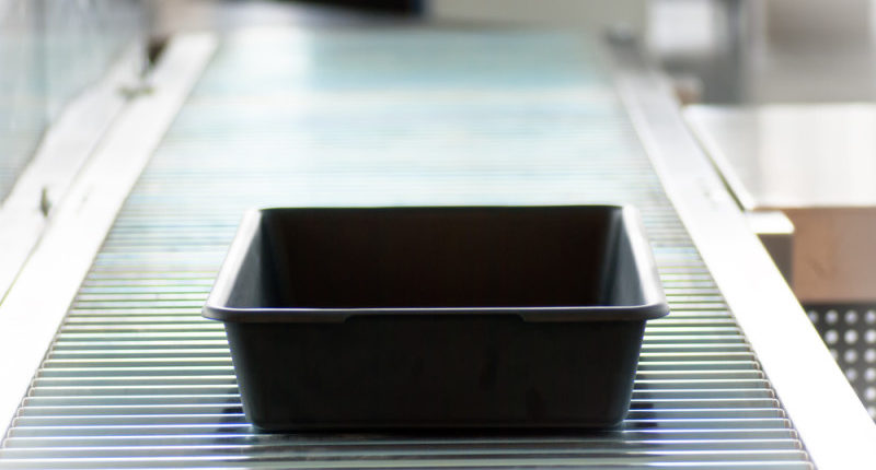 a black rectangular container on a conveyor belt