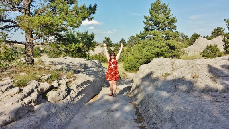 a woman standing on a path with her arms up