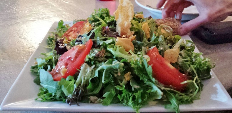 a plate of salad with tomatoes and croutons