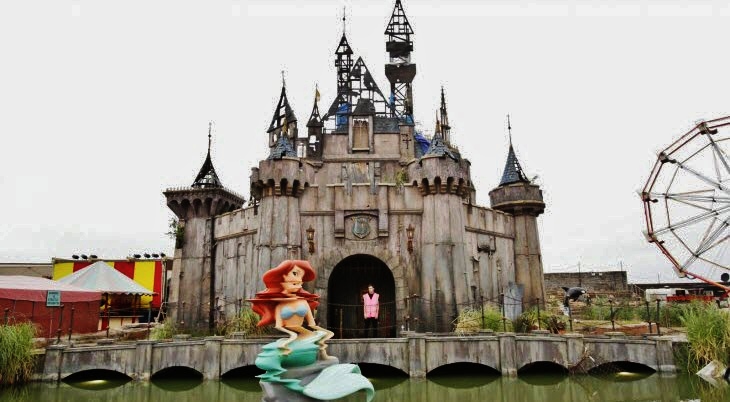 a statue of a mermaid in front of a castle