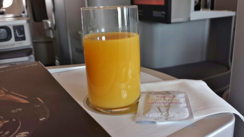 a glass of orange juice and a packet of refreshment