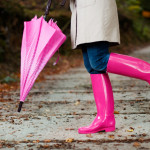 a person wearing pink rain boots and holding a pink umbrella