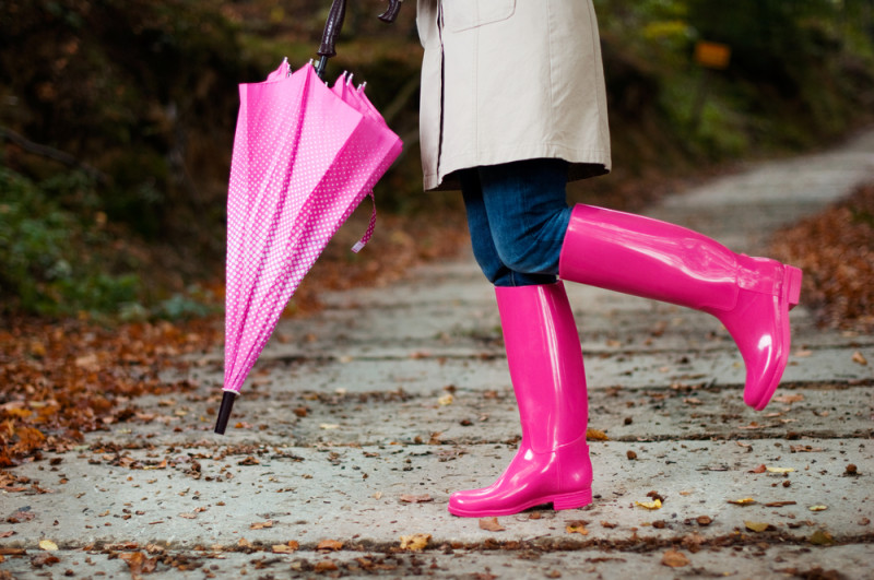 a person wearing pink rain boots and holding a pink umbrella