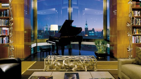 a piano in a room with a view of the city