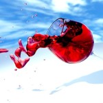 a glass of red wine being dropped