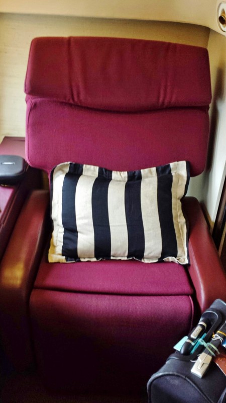a red recliner with a black and white pillow