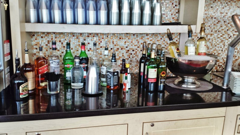 a bar with bottles of alcohol and cups