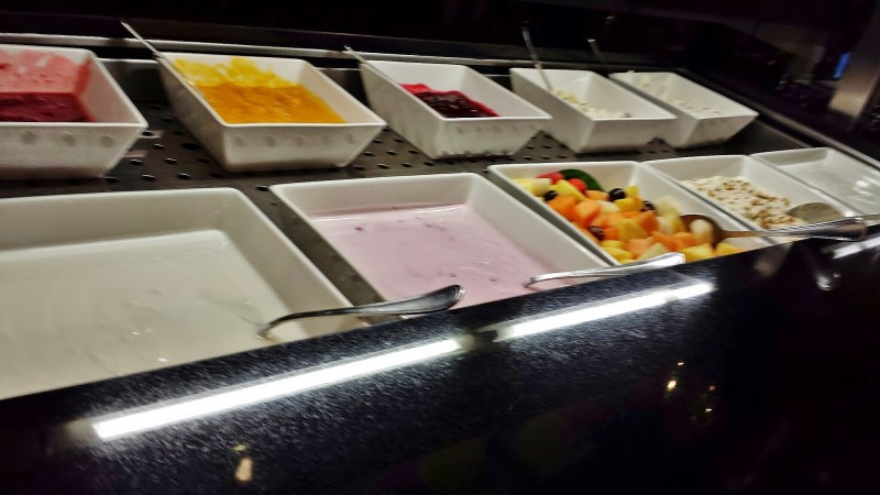 a row of bowls of fruit and yogurt