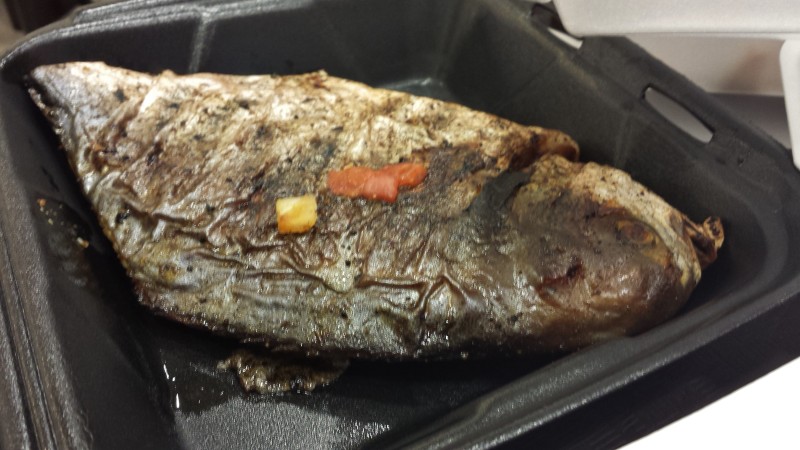 a piece of cooked fish in a black container