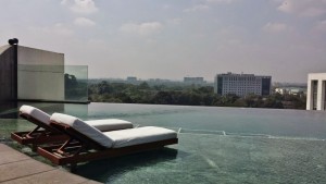 a pool with lounge chairs and a city in the background