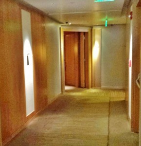 a hallway with a door and a green light