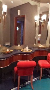 a mirror with red chairs and a tray of soap on it