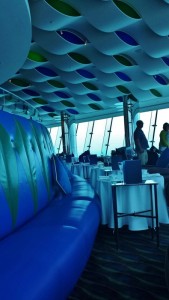 a blue couch in a room with tables and chairs