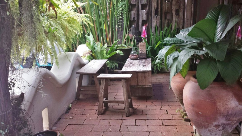 a patio with a bench and plants