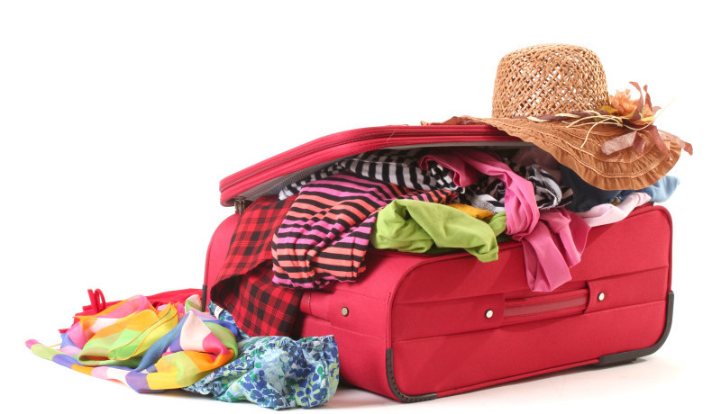 a suitcase full of clothes and a hat