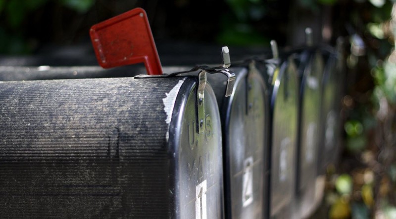 a row of mailboxes with a red flag