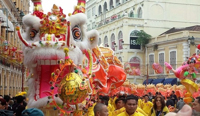 a group of people in yellow shirts and a lion dance garment