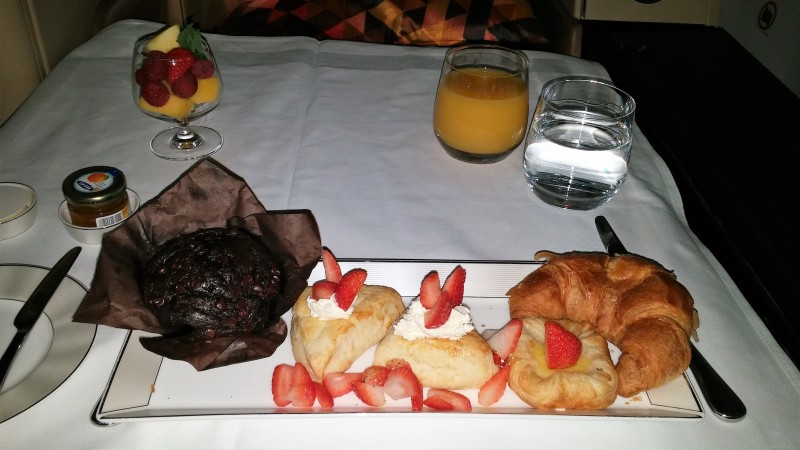 a plate of pastries and fruit on a table