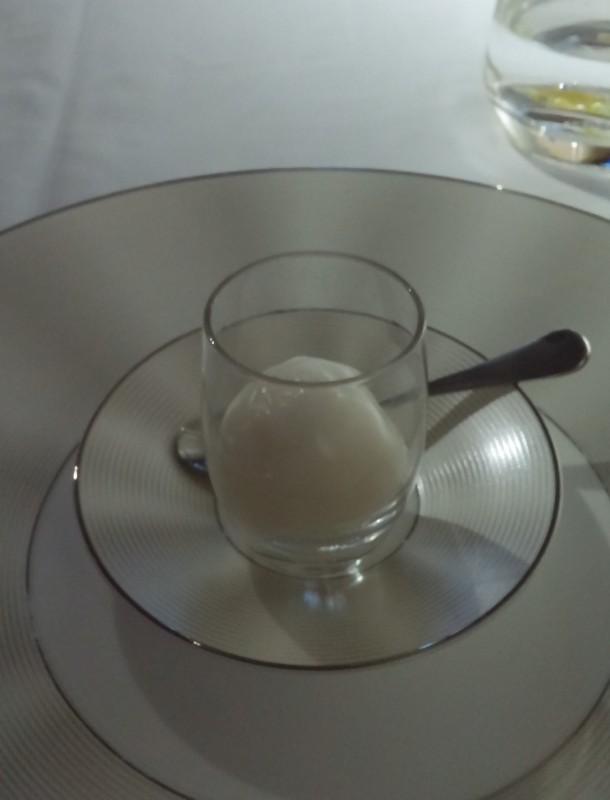 a glass cup with a spoon on a plate