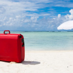 a red suitcase on a beach