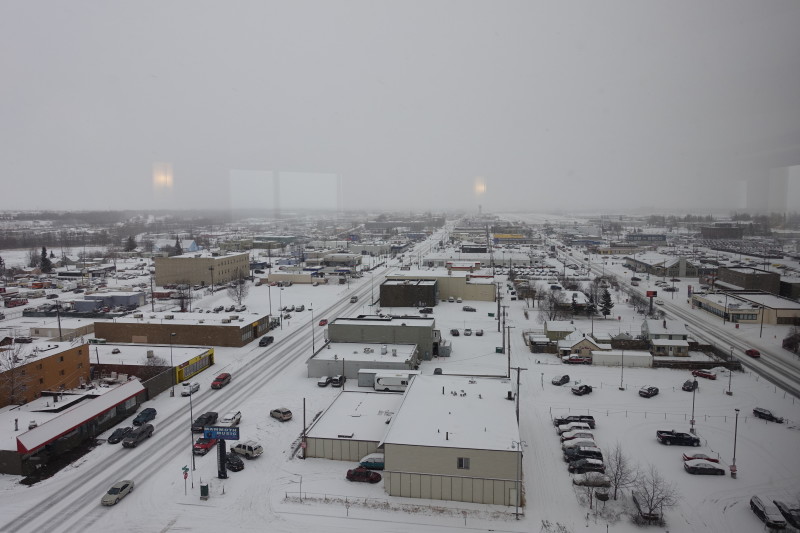a snow covered city with cars and buildings