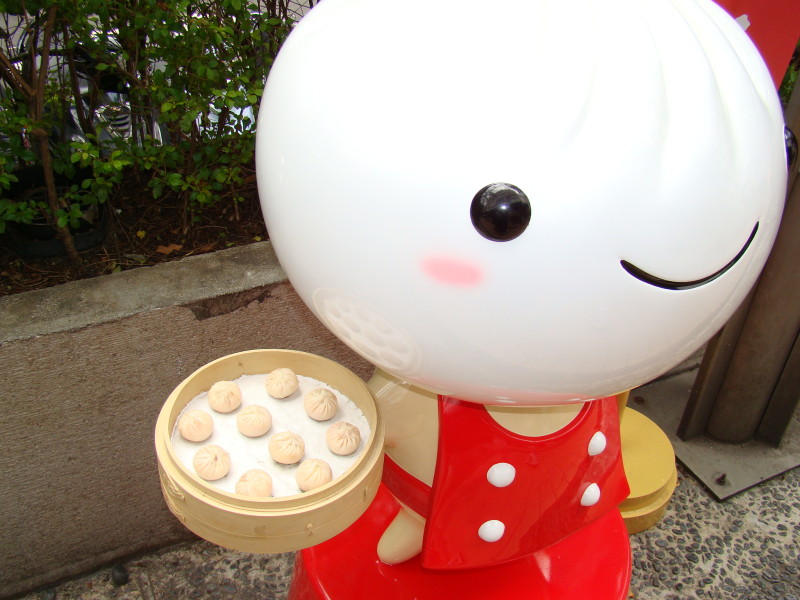 a statue of a person holding a plate of dumplings