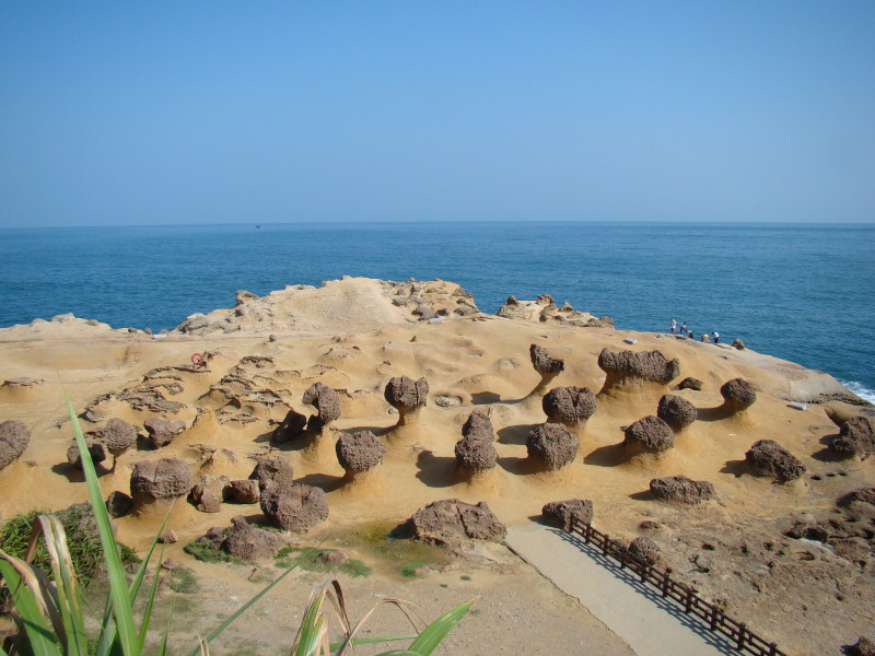 a sandy area with many rocks and a body of water