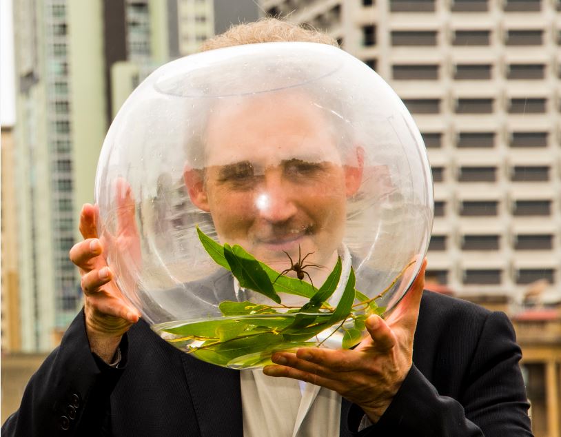 a man holding a transparent ball with leaves in it