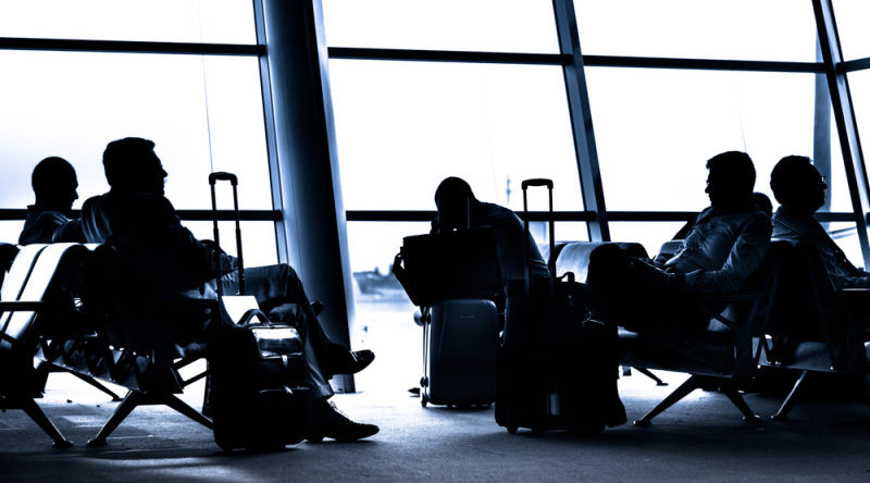 a group of people sitting in chairs with luggage