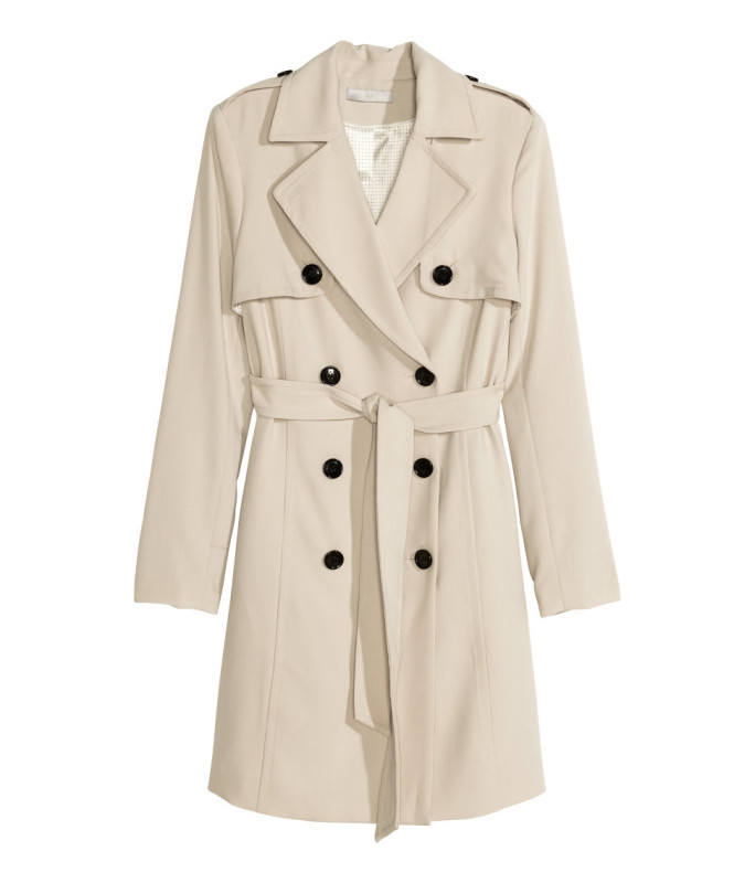 a beige trench coat with black buttons