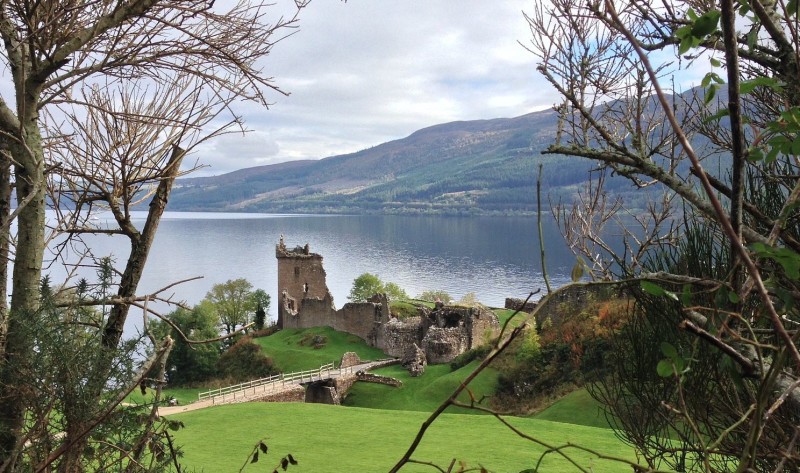 a castle on a hill by a lake