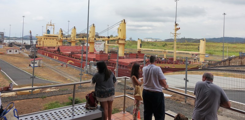 people standing on a deck looking at a ship