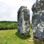 a stone structure in a grassy field