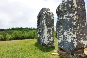 a stone structure in a grassy field