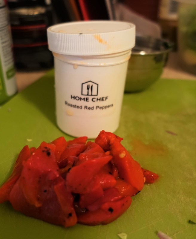 a pile of red peppers on a cutting board