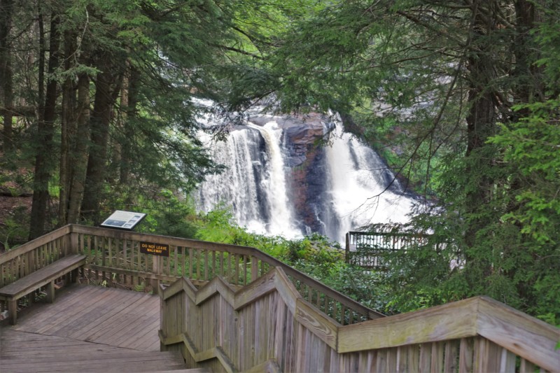 a wooden walkway leading to a waterfall