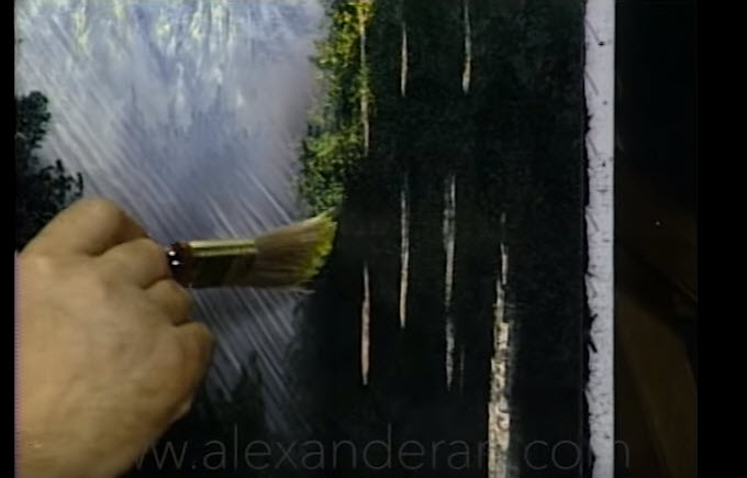 a hand holding a paintbrush over a painting