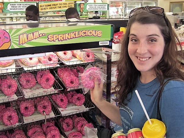 a woman holding a pink donut
