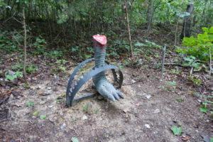 a dinosaur statue in the woods