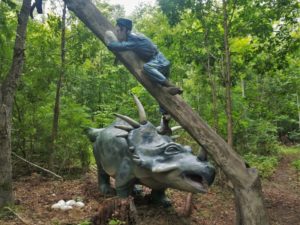 a statue of a dinosaur climbing a tree