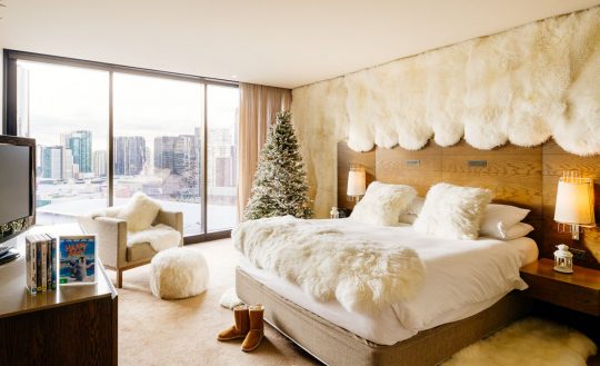 a bedroom with a christmas tree and a bed