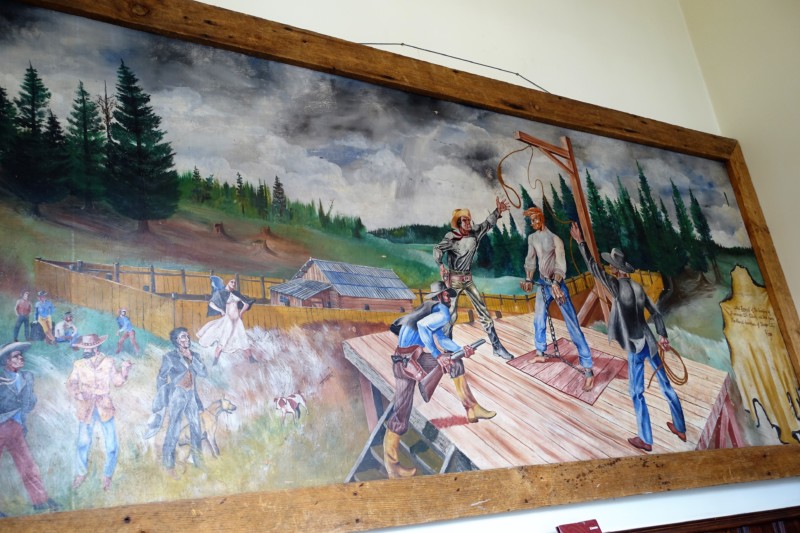 a painting of cowboys on a wall