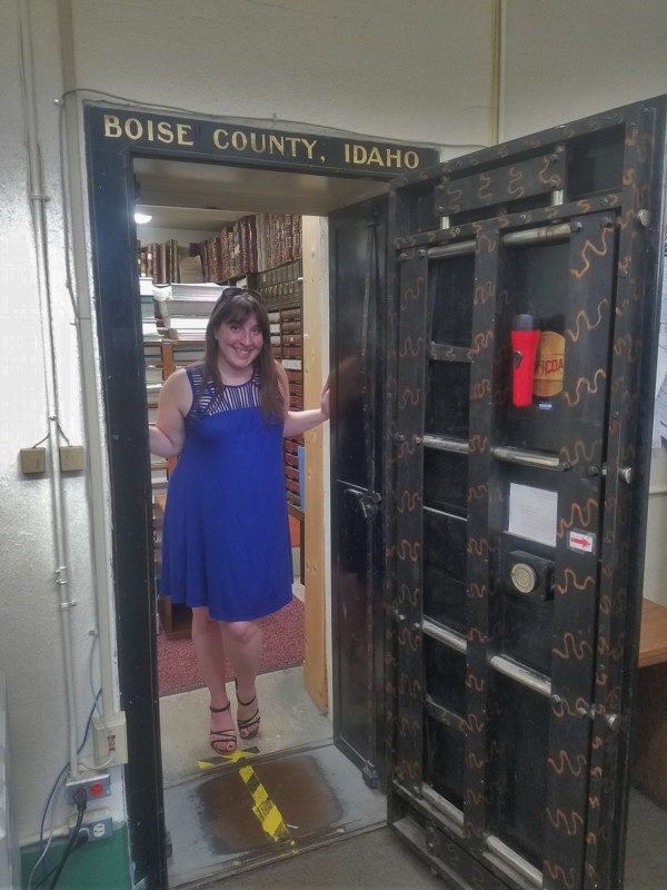 a woman in a blue dress standing in a doorway of a bank