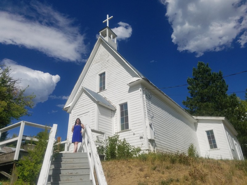 a woman standing on stairs outside a white church