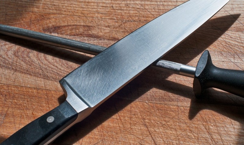 a knife and a pen on a cutting board