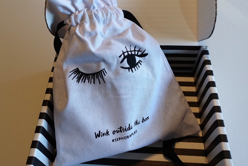 a white bag with eyelashes and eyes drawn on it